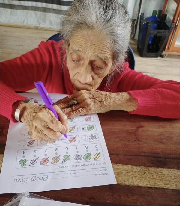 Una adulta mayor resuelve un ejercicio de memoria en su casa
